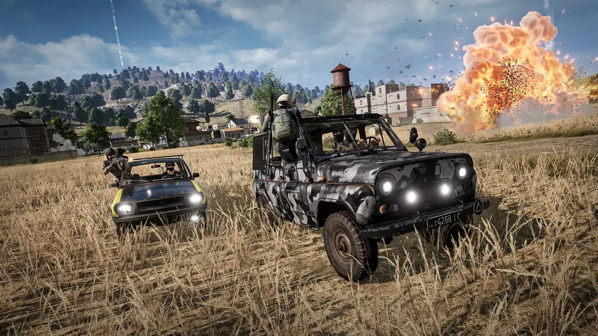 PUBG: 배틀그라운드 게임플레이 스크린샷, 들판을 달리는 차량 두 대와 멀리서 일어나는 폭발